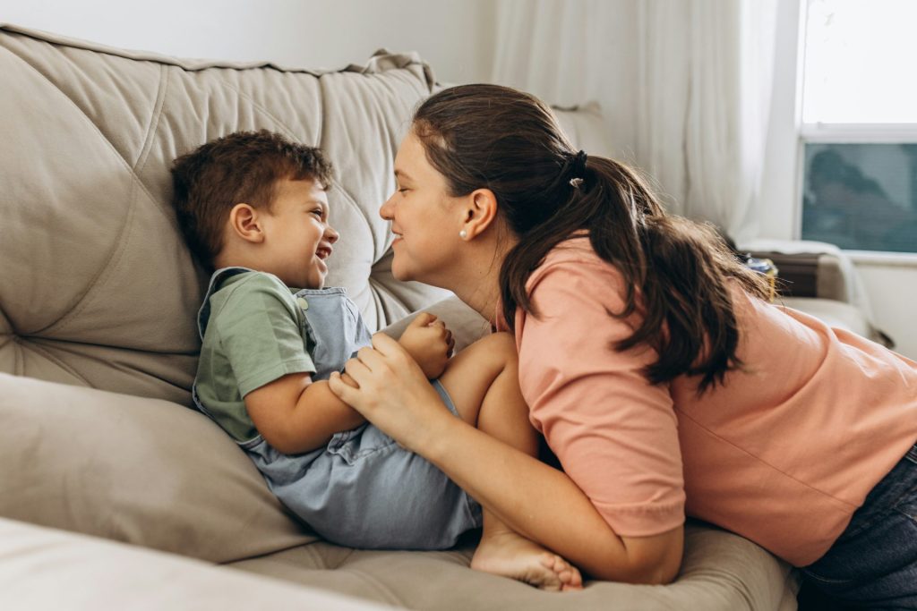 Eine Frau und ein Junge spielen auf einem Sofa