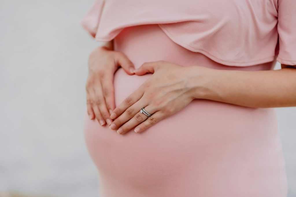 Frau mit Goldring und rosa Kleid
