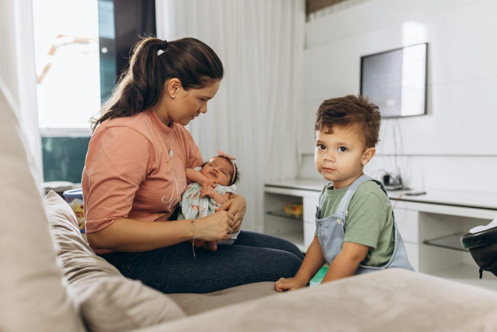 Eine Frau sitzt auf einem Sofa und hält ein Baby.